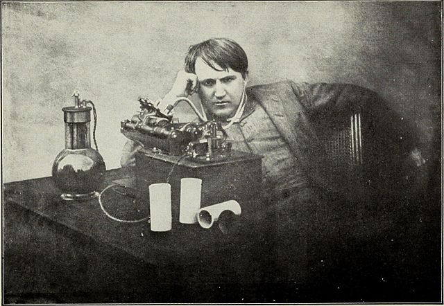 A young Thomas Edison sitting beside his phonograph